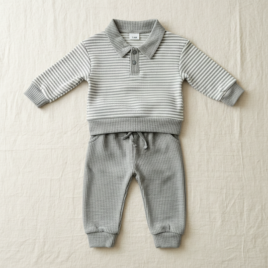 Grey striped baby outfit on a clean neutral background